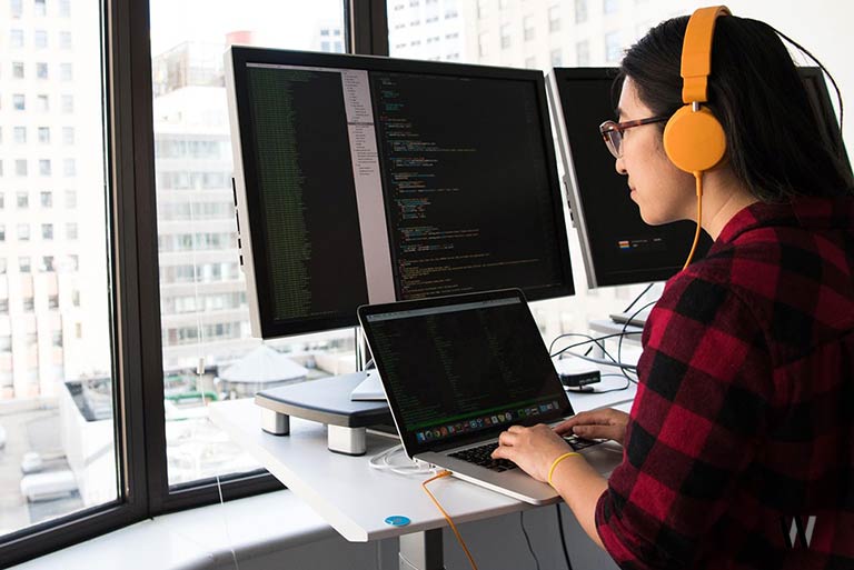 Woman with Headphones Working on a Computer